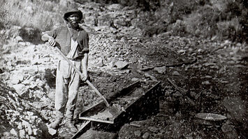 An African American Miner holding a shovel above a sluice box at Auburn Ravine, 1852