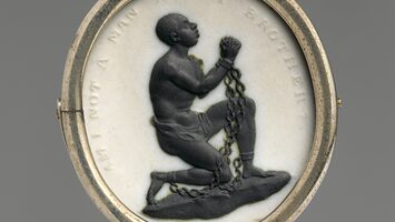 A medallion with the image of a kneeling, chained black man with clasped hands surrounded by the words "Am I not a man and a brother?"