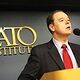 David Boaz stands behind a lectern, with the Cato Institute logo on the wall behind him.