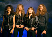 Kirk Hammett, James Hetfield, Lars Ulrich, and Cliff Burton stand in front of a stormy backdrop.